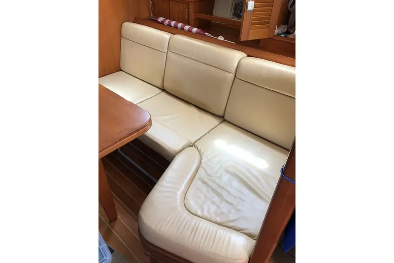 Slide: The Image of Cream leather seating in 2006 Island Packet 440 yacht interior, featuring wooden accents. - 68
