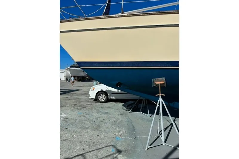 Slide: The Image of Island Packet 440 sailboat from 2006 on dry dock, with a car nearby. - 38
