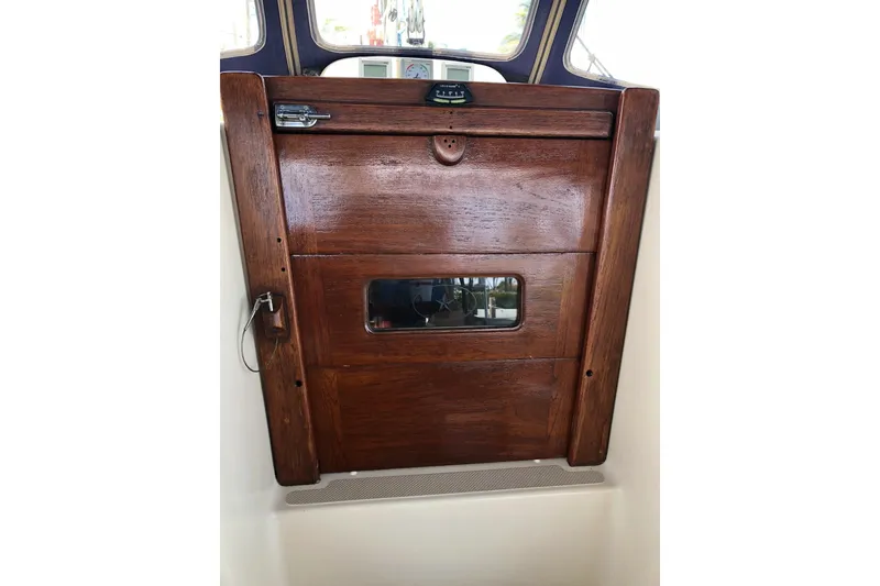 Slide: The Image of Wooden cabin door of 2006 Island Packet 440 sailboat with window and latch. - 22