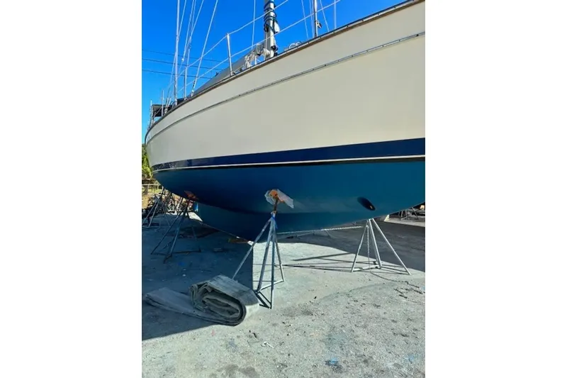 Slide: The Image of 2006 Island Packet 440 sailboat on stands, showcasing hull and keel in a boatyard. - 39