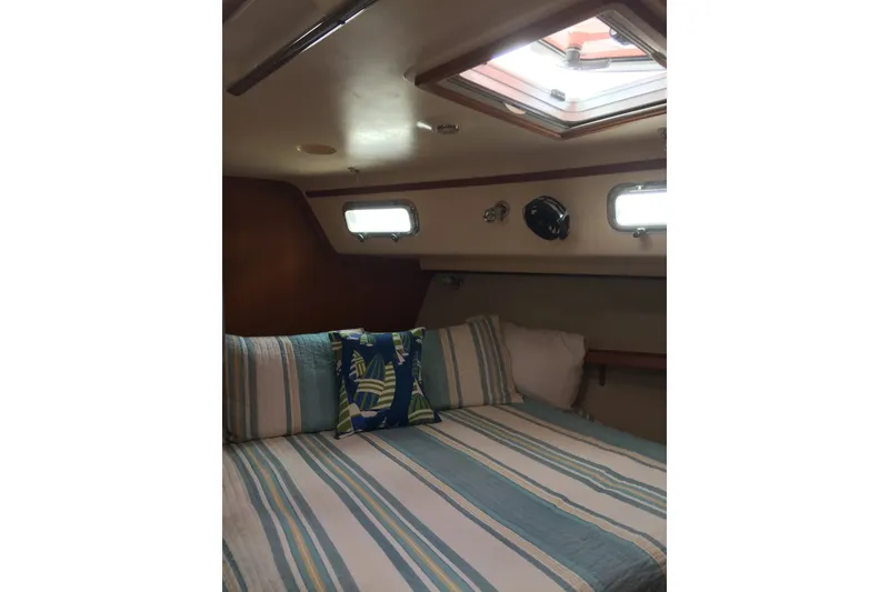 Slide: The Image of Cozy cabin interior of 2006 Island Packet 440 sailboat with striped bedding and portholes. - 44