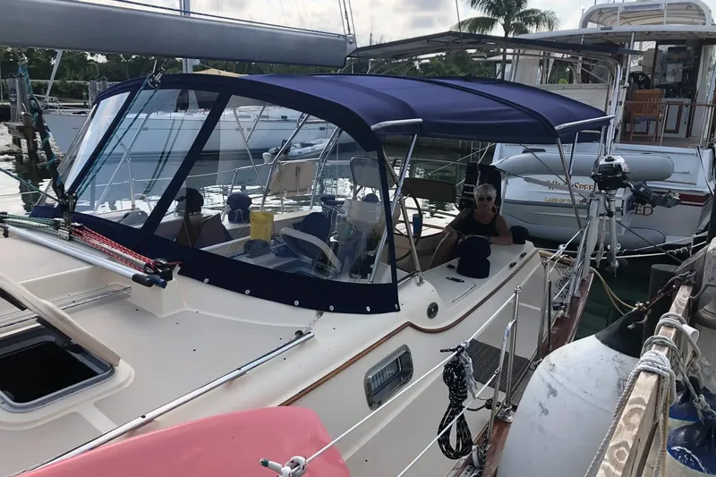 Slide: The Image of 2006 Island Packet 440 sailboat docked with blue canopy and visible marina background. - 56