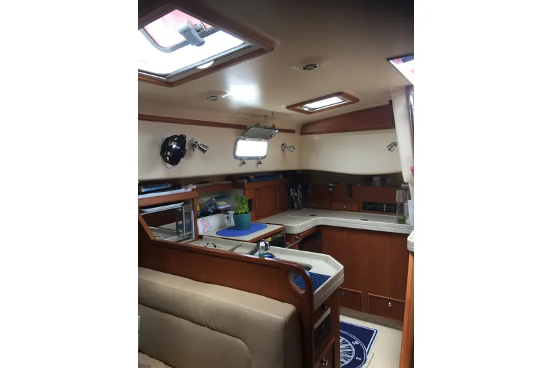 Slide: The Image of Interior of 2006 Island Packet 440 yacht, featuring a cozy kitchen and seating area. - 47
