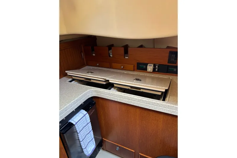 Slide: The Image of 2006 Island Packet 440 yacht galley with wooden cabinetry and compact appliances. - 65