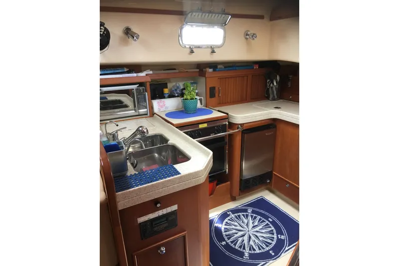 Slide: The Image of Interior of 2006 Island Packet 440 yacht kitchen with sink, stove, and nautical decor. - 48