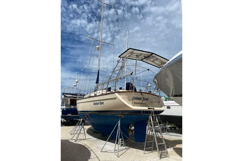 Slide: The Image of 2006 Island Packet 440 sailboat on dry dock under a partly cloudy sky. - 36