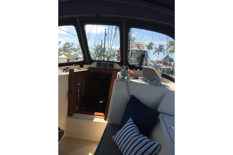 Slide: The Image of Interior view of 2006 Island Packet 440 sailboat cockpit with cushions and ropes. - 17