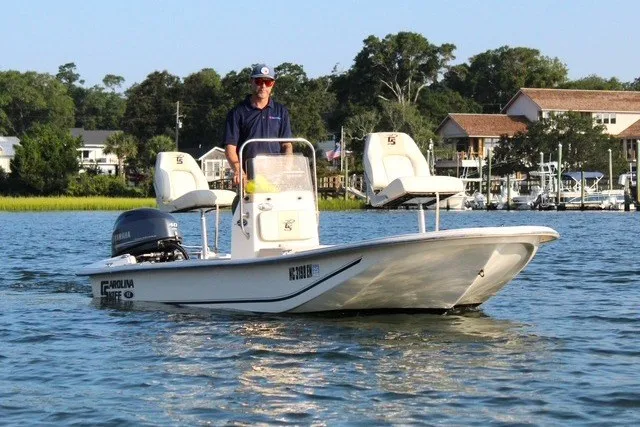 Slide: The Image of 2019 Carolina Skiff 17 JV CC boat on water with driver, scenic background. - 1