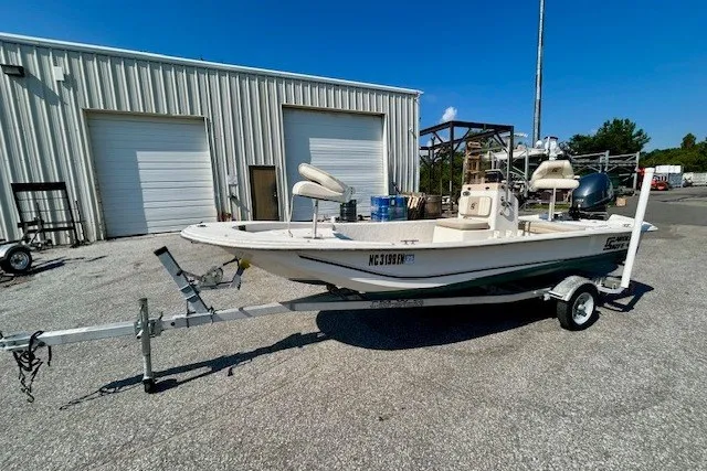 Slide: The Image of 2019 Carolina Skiff 17 JV CC boat on trailer, parked outside industrial building. - 12