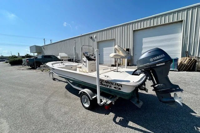 Slide: The Image of 2019 Carolina Skiff 17 JV CC boat with Yamaha motor on trailer, parked outside warehouse. - 13