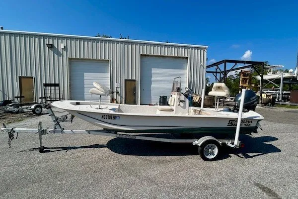 Slide: The Image of 2019 Carolina Skiff 17 JV CC boat on trailer, parked outside industrial building. - 11