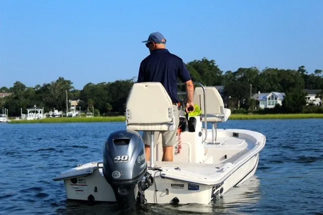 Slide: The Image of Man steering 2019 Carolina Skiff 17 JV CC boat on calm water. - 3
