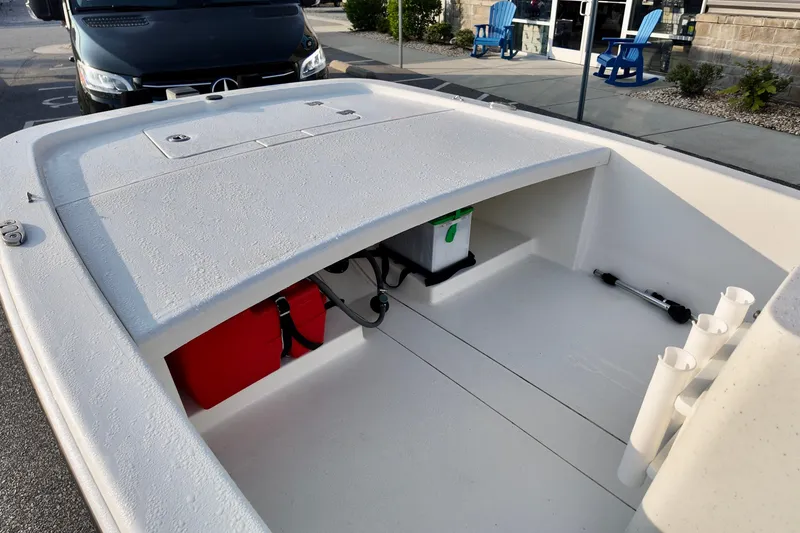 Slide: The Image of 2023 Mako Pro Skiff 13 CC boat interior with storage compartments and rod holders. - 5