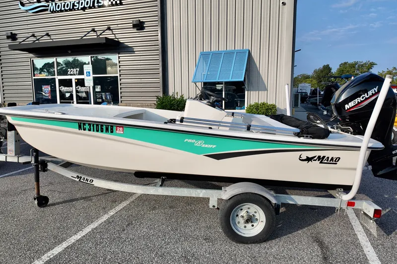 Slide: The Image of 2023 Mako Pro Skiff 13 CC boat on trailer outside dealership. - 2