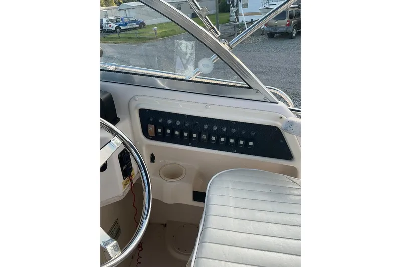 Slide: The Image of 2005 Grady-White Seafarer 226 boat dashboard with steering wheel and control panel. - 13