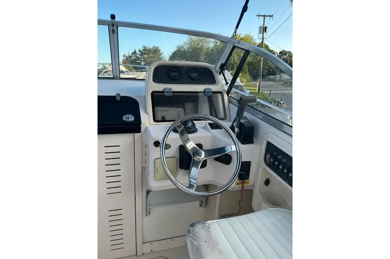 Slide: The Image of 2005 Grady-White Seafarer 226 boat helm with steering wheel and control panel. - 14