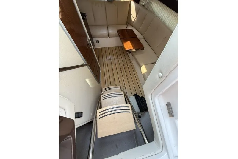 Slide: The Image of Interior of 2015 Regal 32 Express boat with beige seating and wooden flooring. - 36