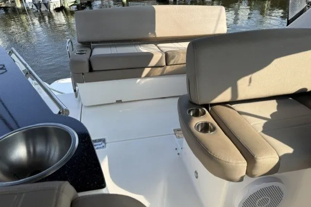 Slide: The Image of 2015 Regal 32 Express boat interior with beige seating and cup holders. - 32