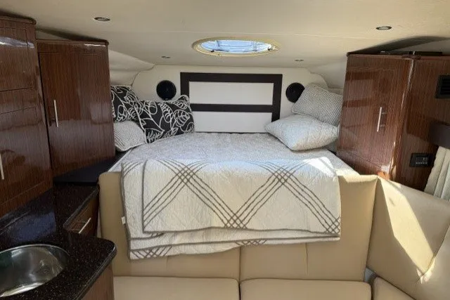 Slide: The Image of Interior cabin of 2015 Regal 32 Express boat with cozy bed and modern wood finish. - 17