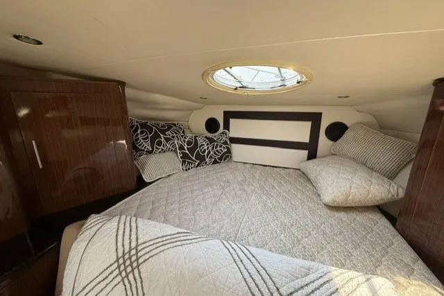 Slide: The Image of Cozy cabin interior of 2015 Regal 32 Express yacht with plush bedding and elegant wood finishes. - 34