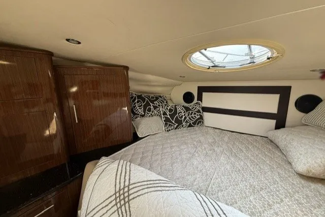 Slide: The Image of Interior cabin of 2015 Regal 32 Express boat with bed and wooden cabinets. - 24