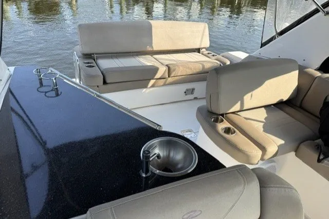 Slide: The Image of 2015 Regal 32 Express boat interior with seating and sink, docked on calm water. - 37