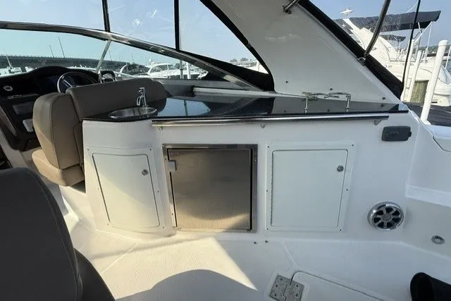 Slide: The Image of 2015 Regal 32 Express yacht interior with kitchenette and seating area. - 38
