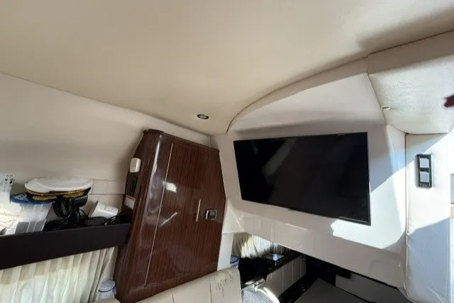 Slide: The Image of Interior of 2015 Regal 32 Express yacht with TV and wooden cabinetry. - 16
