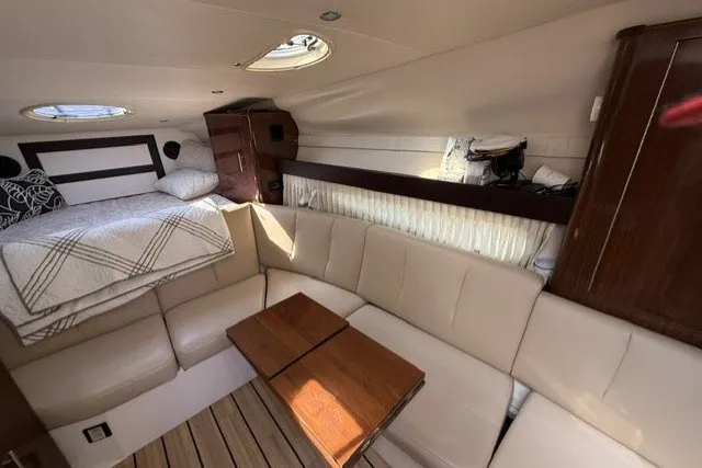 Slide: The Image of Interior of a 2015 Regal 32 Express boat with beige seating and a cozy bed area. - 43