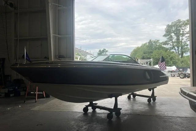 Slide: The Image of 2019 Chris-Craft Launch 23 boat in a garage, side view with flags. - 5