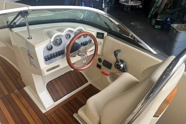 Slide: The Image of 2019 Chris-Craft Launch 23 boat interior with wooden steering wheel and dashboard controls. - 13