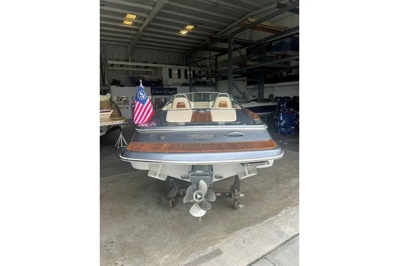 Slide: The Image of 2019 Chris-Craft Launch 23 boat in storage, rear view with American flag. - 3