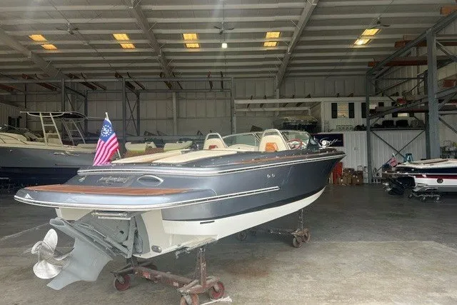 Slide: The Image of 2019 Chris-Craft Launch 23 boat in a storage facility, featuring sleek design and American flag. - 1