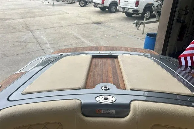 Slide: The Image of 2019 Chris-Craft Launch 23 boat with teak deck and beige upholstery in a marina setting. - 9