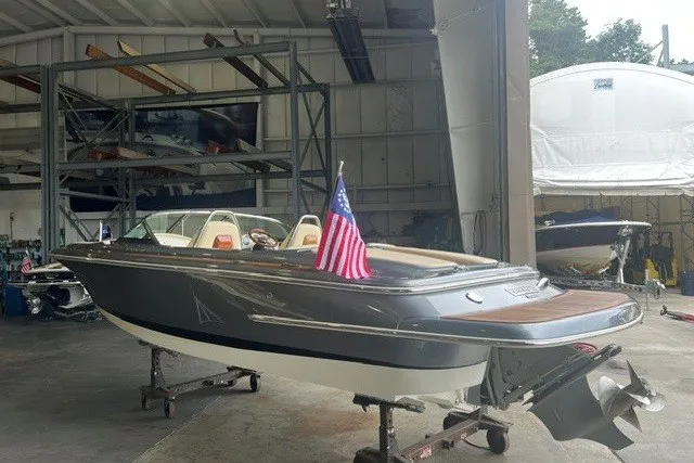 Slide: The Image of 2019 Chris-Craft Launch 23 boat in a warehouse, featuring sleek design and American flag. - 6