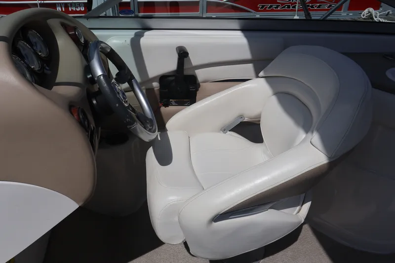 Slide: The Image of Interior of a 2006 Four Winns H240 boat showing steering wheel and white captain's chair. - 29