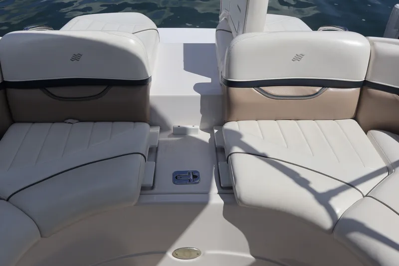 Slide: The Image of 2006 Four Winns H240 boat interior with white leather seating and water background. - 18