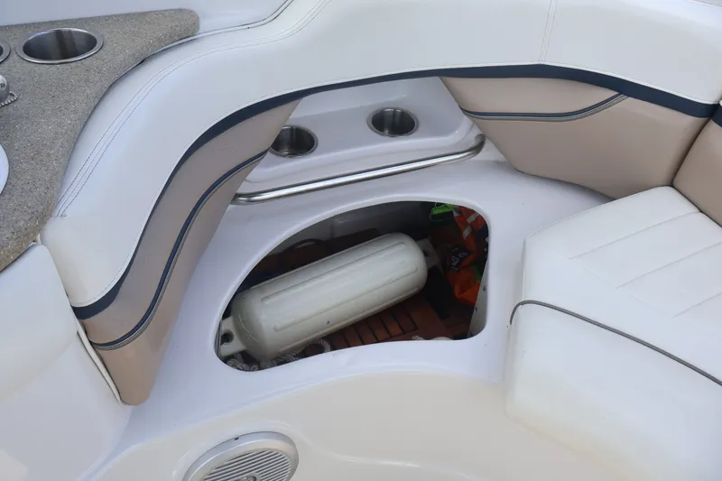 Slide: The Image of 2006 Four Winns H240 boat interior with storage compartment and cup holders. - 38