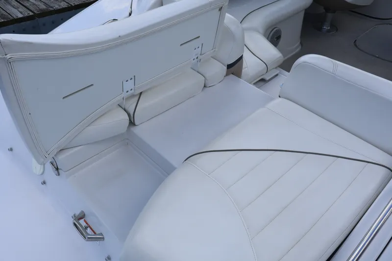 Slide: The Image of 2006 Four Winns H240 boat interior with white cushioned seating and storage compartment. - 14