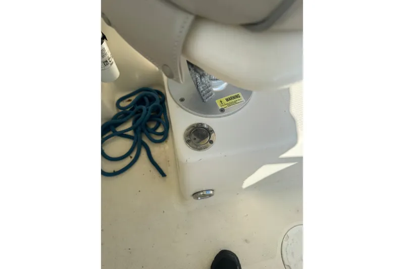 Slide: The Image of 2004 Scout 242 Abaco boat interior with blue rope and warning label. - 14