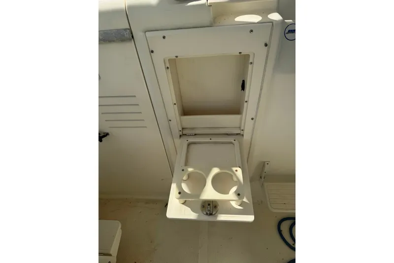 Slide: The Image of 2004 Scout 242 Abaco boat interior with open storage compartment and cup holders. - 13