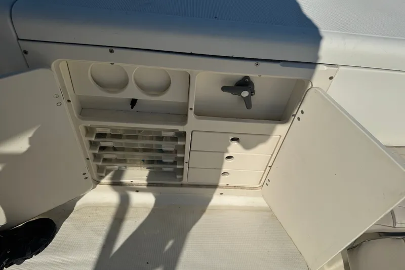 Slide: The Image of Open storage compartment on a 2004 Scout 242 Abaco boat, featuring shelves and drawers. - 8