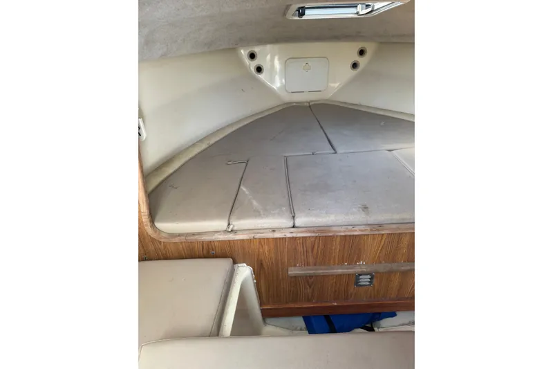 Slide: The Image of 2004 Scout 242 Abaco cabin interior with cushioned seating and wooden accents. - 16