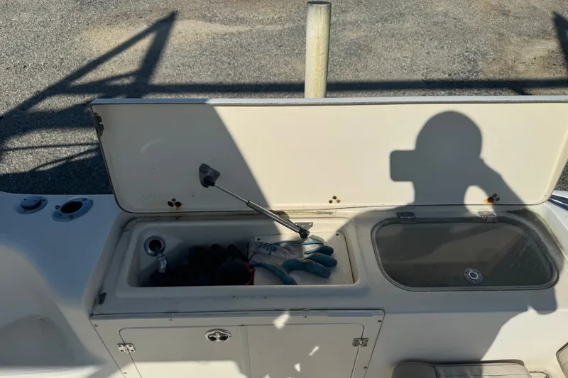 Slide: The Image of Open storage compartment on 2004 Scout 242 Abaco boat with gloves and tools inside. - 7