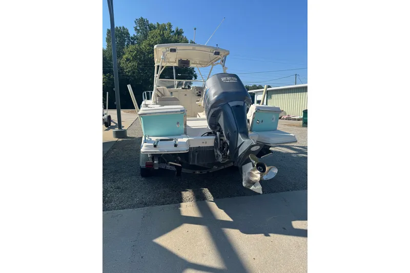 Slide: The Image of 2004 Scout 242 Abaco boat with outboard motor, parked outdoors. - 2