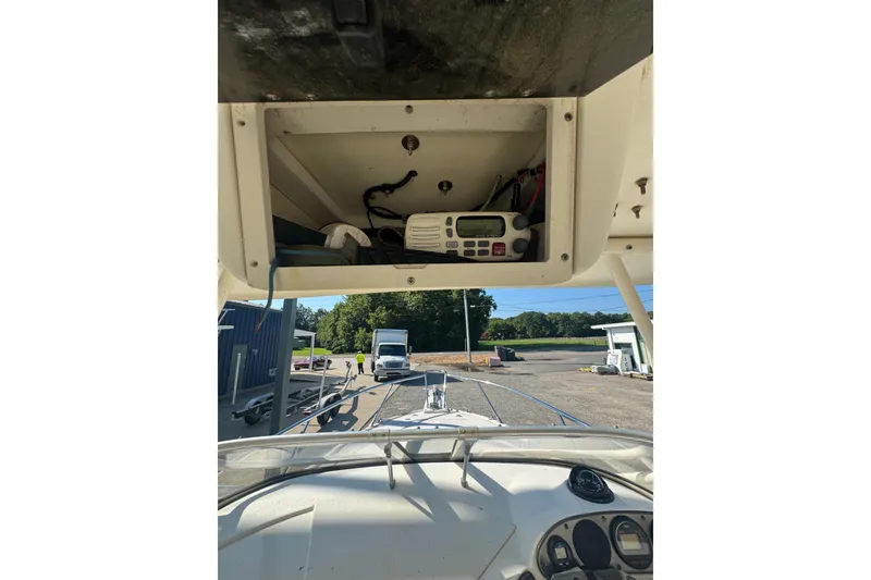 Slide: The Image of 2004 Scout 242 Abaco boat dashboard with radio compartment open. - 19
