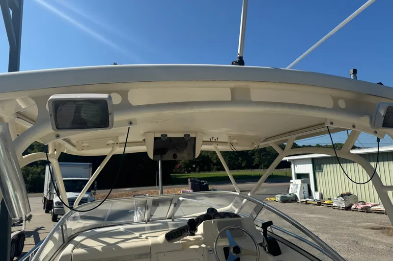 Slide: The Image of 2004 Scout 242 Abaco boat helm with canopy and steering wheel in sunny outdoor setting. - 11
