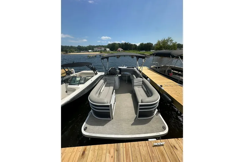 Slide: The Image of 2022 Bennington 22 SS pontoon boat docked on a sunny lake. - 8