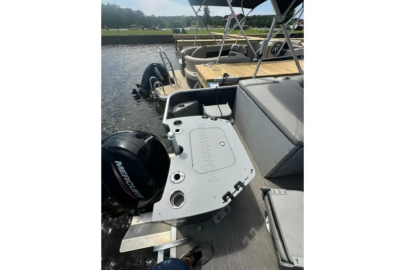 Slide: The Image of 2022 Bennington 22 SS pontoon boat with Mercury outboard motor docked by the water. - 5