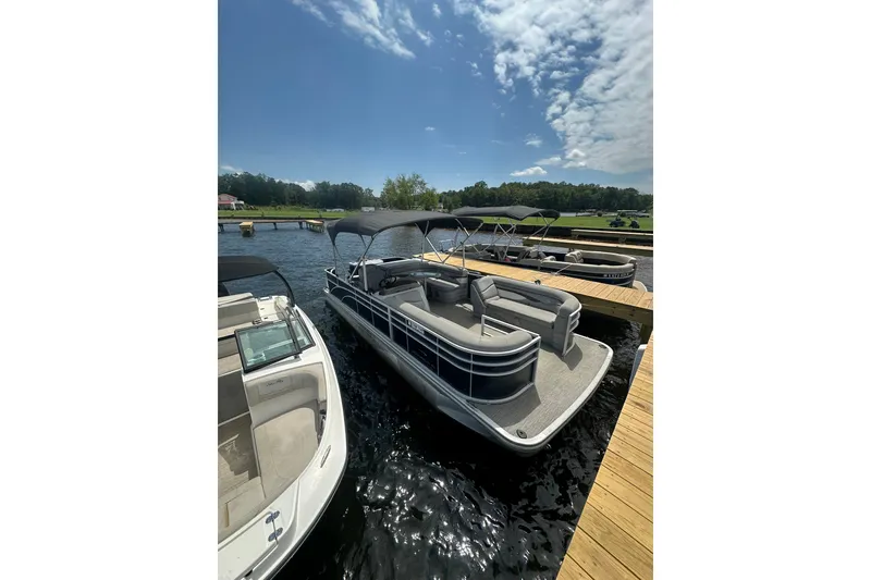 Slide: The Image of 2022 Bennington 22 SS pontoon boat docked on a sunny day. - 2